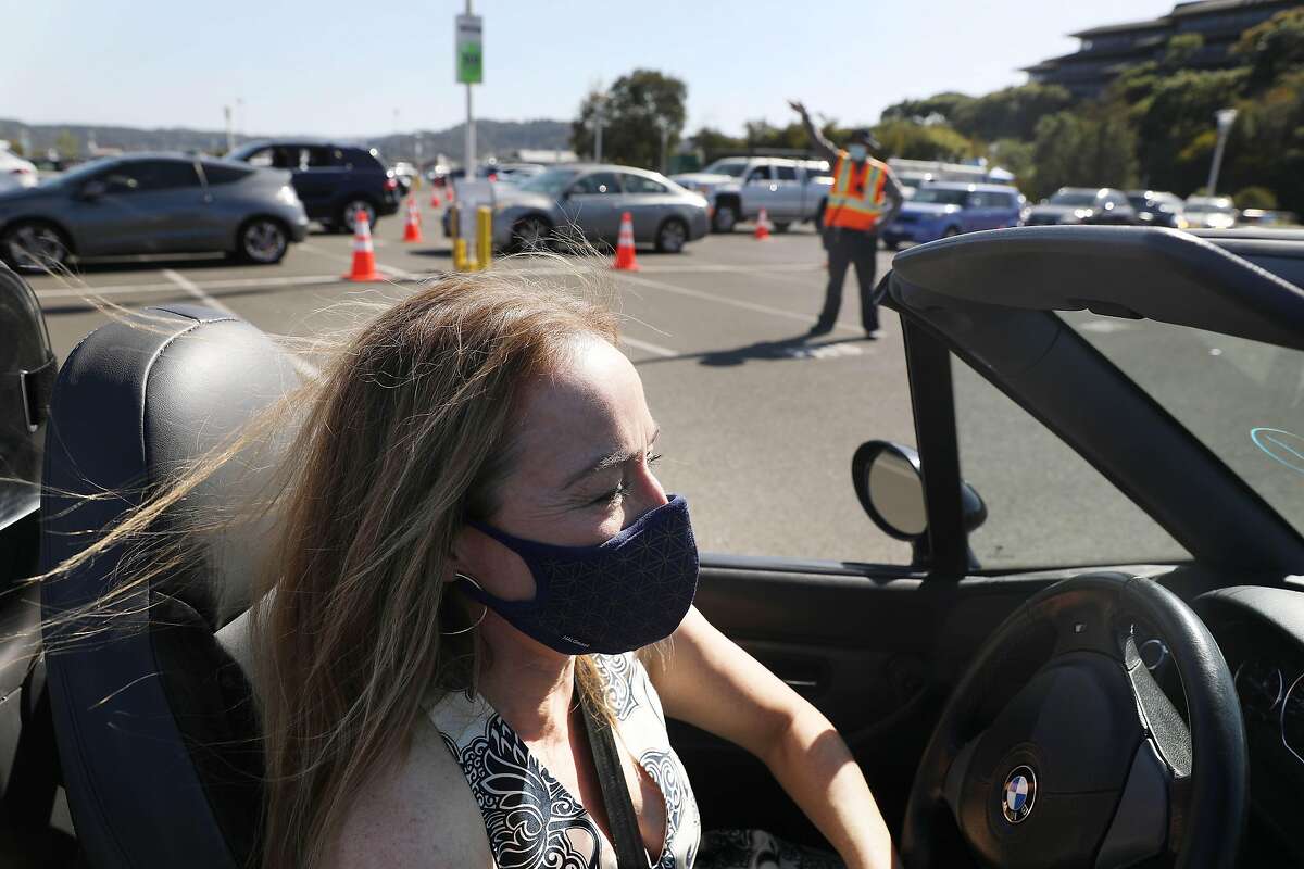 Kristina Skierka of Lucas Valley waits in a line of cars to receive her first dose of COVID-19 vaccine at the Larkspur Ferry Terminal. Marin County officials credited high vaccination rates for the county’s move into the yellow tier Tuesday.