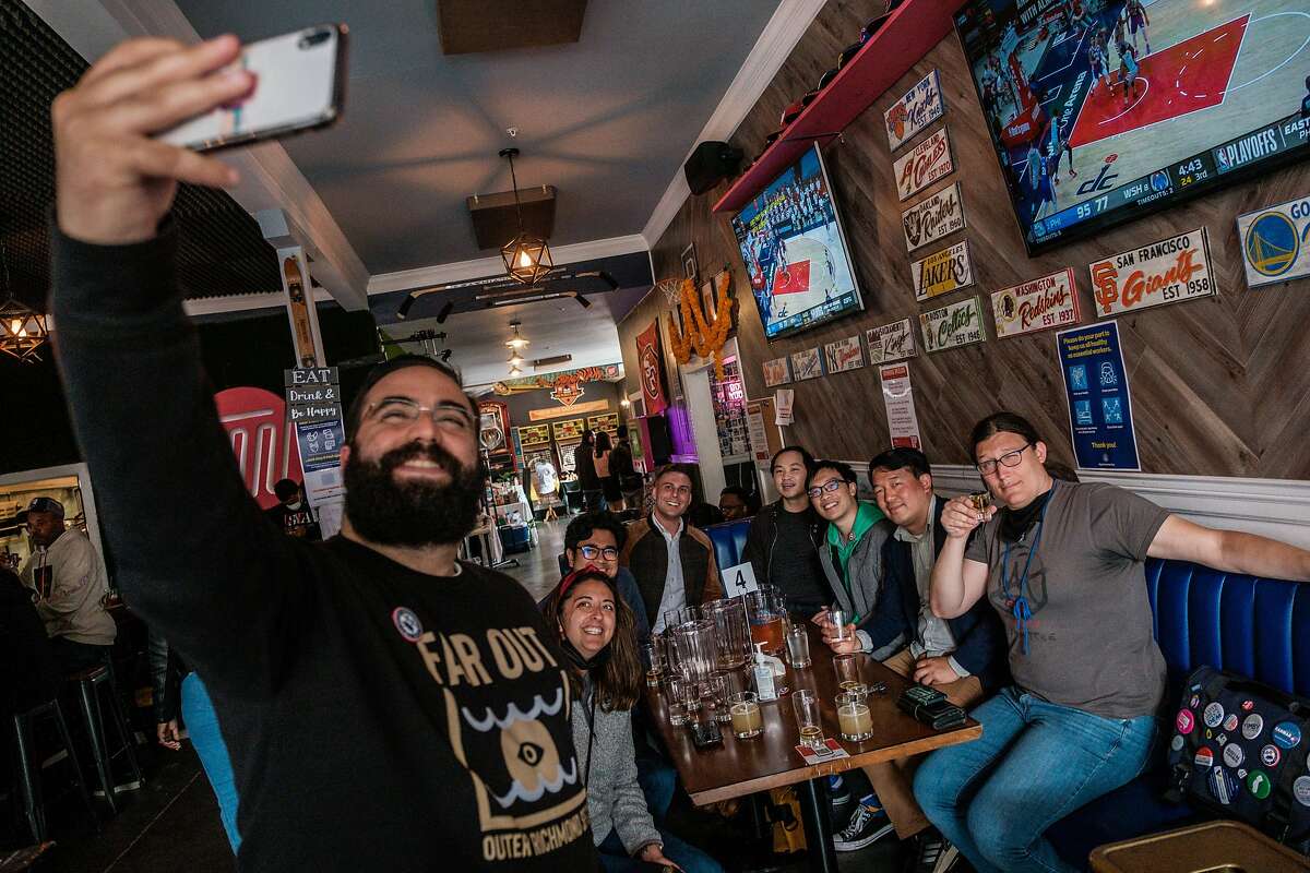 Brian Quan, second from right, poses for a selfie while out with his friends at Trademark & Copyright sportsbar in San Francisco on Saturday, May 29, 2021. Mr. Quan completed Mayor Breed’s “small business challenge” for the month of May by visiting a variety of small business in alphabetical order.