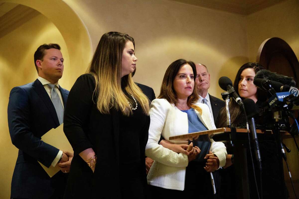 Jacquelyn Aluotto, center, talks to members of the press about alleged sexual misconduct against female deputies, Monday, May 24, 2021, in Houston.