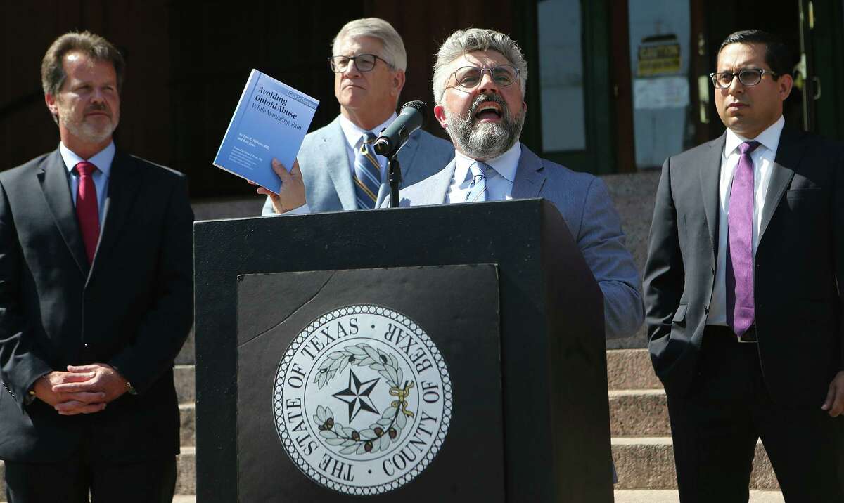 Attorney Martin Phipps (at lectern), shown in this file photo from 2018 at a news conference in front of the Bexar County Courthouse, no longer faces a telephone harassment charge involving his former wife. The case was dismissed Friday.