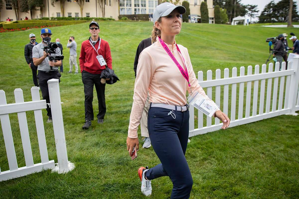 Rachel Heck walks to a media tent to be interviewed before her practice round for the U.S. Women's Open at the Olympic Club, Wednesday, June 2, 2021, in San Francisco, Calif. Her father, Robert Heck (in red), is her caddie.