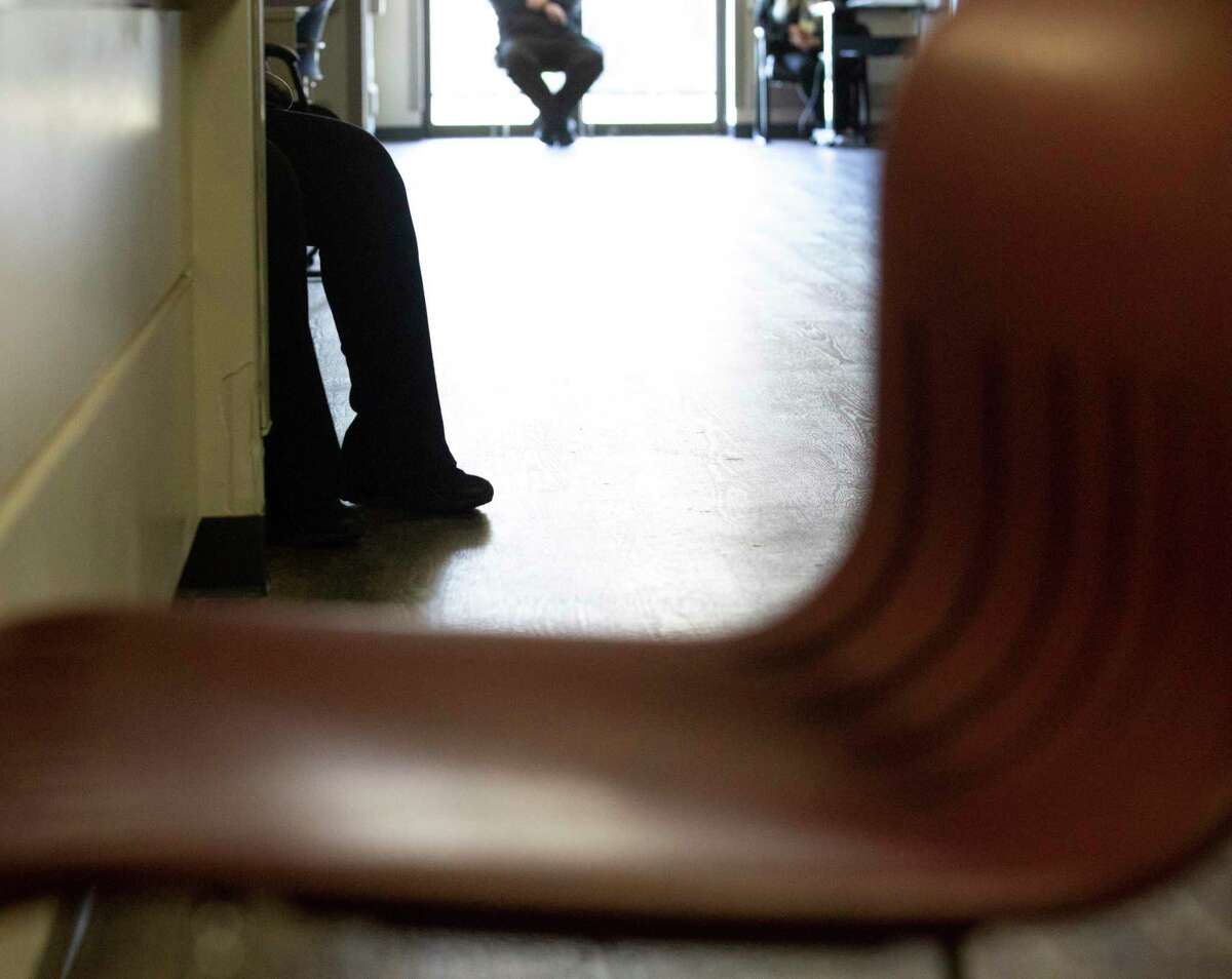 Patients sit in the hallway of the Judge Ed Emmett Harris County Mental Health Diversion Center in Houston in December 2020. From fall 2018 through Jan. 31, 2021, there have been about 3,500 diversions to the center.