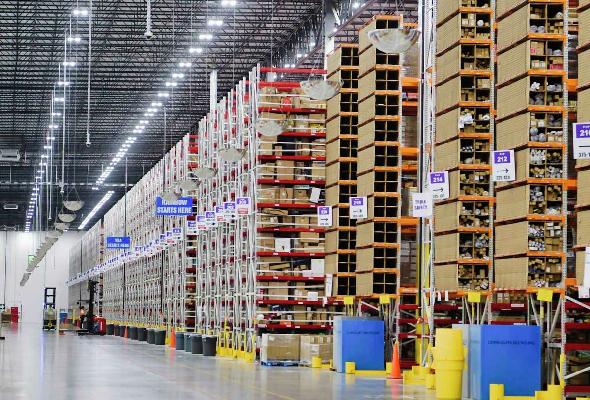 Employees move around in powered industrial trucks (PIT machines) either stocking product on shelves or pulling product for an order at the Amazon fulfillment center on Wednesday, June 2, 2021, in Schodack, N.Y. From the fulfillment center packages are sent to an Amazon sortation center or a delivery station. (Paul Buckowski/Times Union)