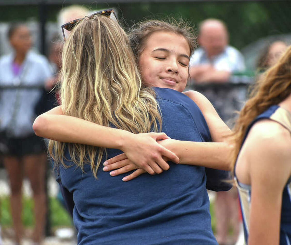 Father McGivney freshman Kaitlyn Hatley hugs a coach after her win in the 800-meter run at the Class 1A Belleville Althoff Sectional.
