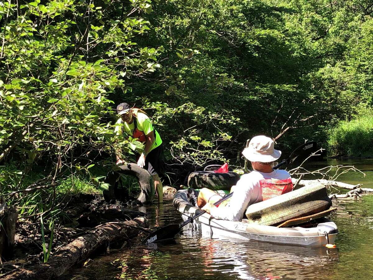 Volunteers pick up trash while boating along the Muskegon River during the Muskegon River Trash Bash. (Photo courtesy of Joseph Lisuzzo)