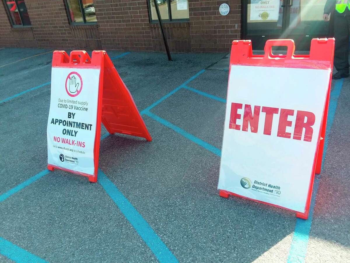 This file photo shows signs at a District Health Department No. 10 COVID-19 vaccine clinic in Manistee in March. DHD#10 is issuing guidance for at-home COVID-19 tests to ensure that the tests work and are accurate during Michigan's cold winter.   