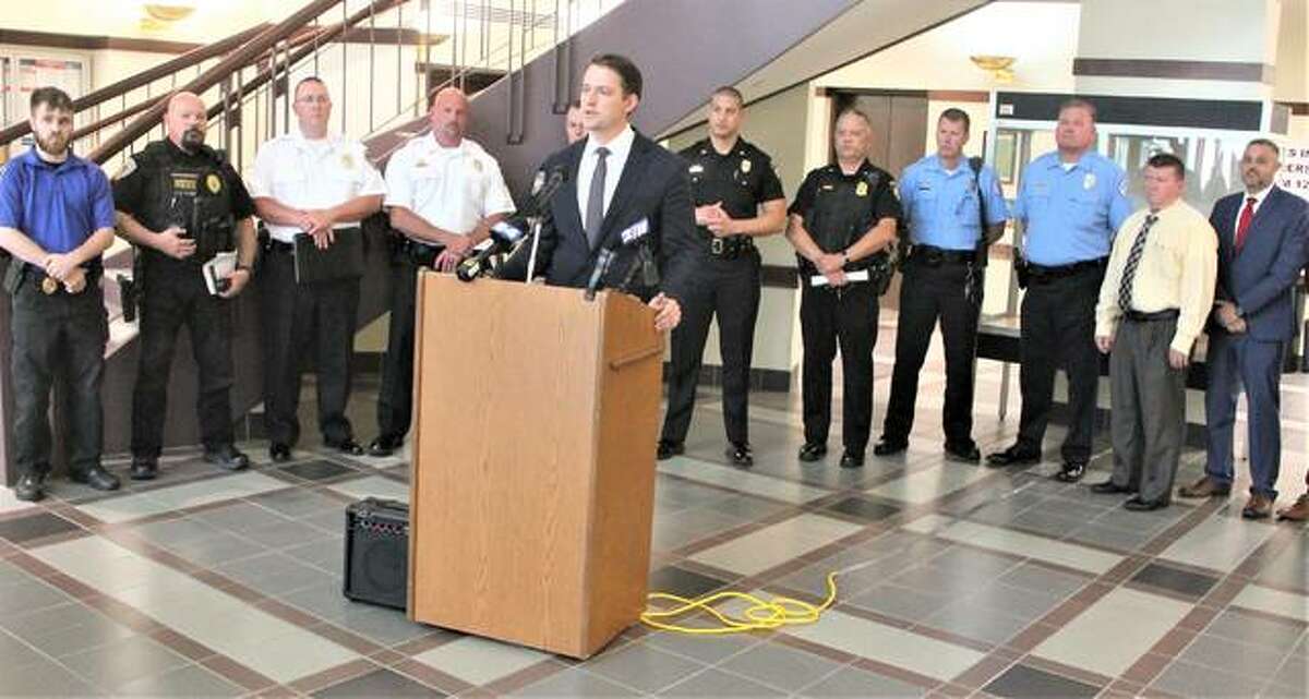 Flanked by local law enforcement officials, Madison County State’s Attorney Tom Haine gives an update on the “Cross-River Crime Task Force” Thursday at the Madison County Administration Building, in Edwardsville. The task force formed in April to deal with increasing crime and criminals coming to the state from Missouri.