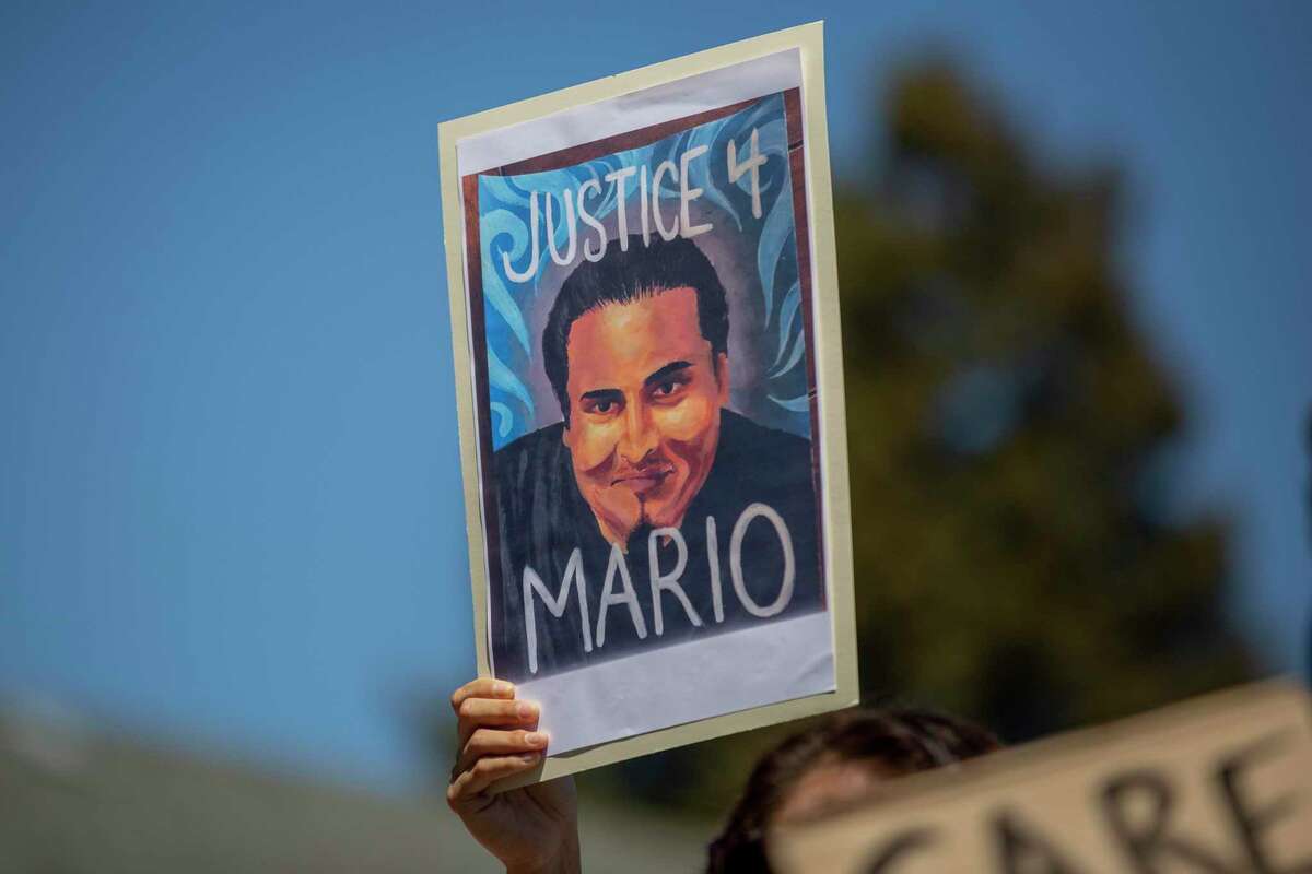 A person holds up a “Justice 4 Mario” sign while listening in to an April 27 news conference hosted by Mario Gonzalez’s family and supporters outside the Alameda Police Department. Gonzalez’s death resulted from the “toxic effects of methamphetamine,” combined with the “physiological stress” of restraint by officers and other underlying conditions, according to the Alameda County coroner.