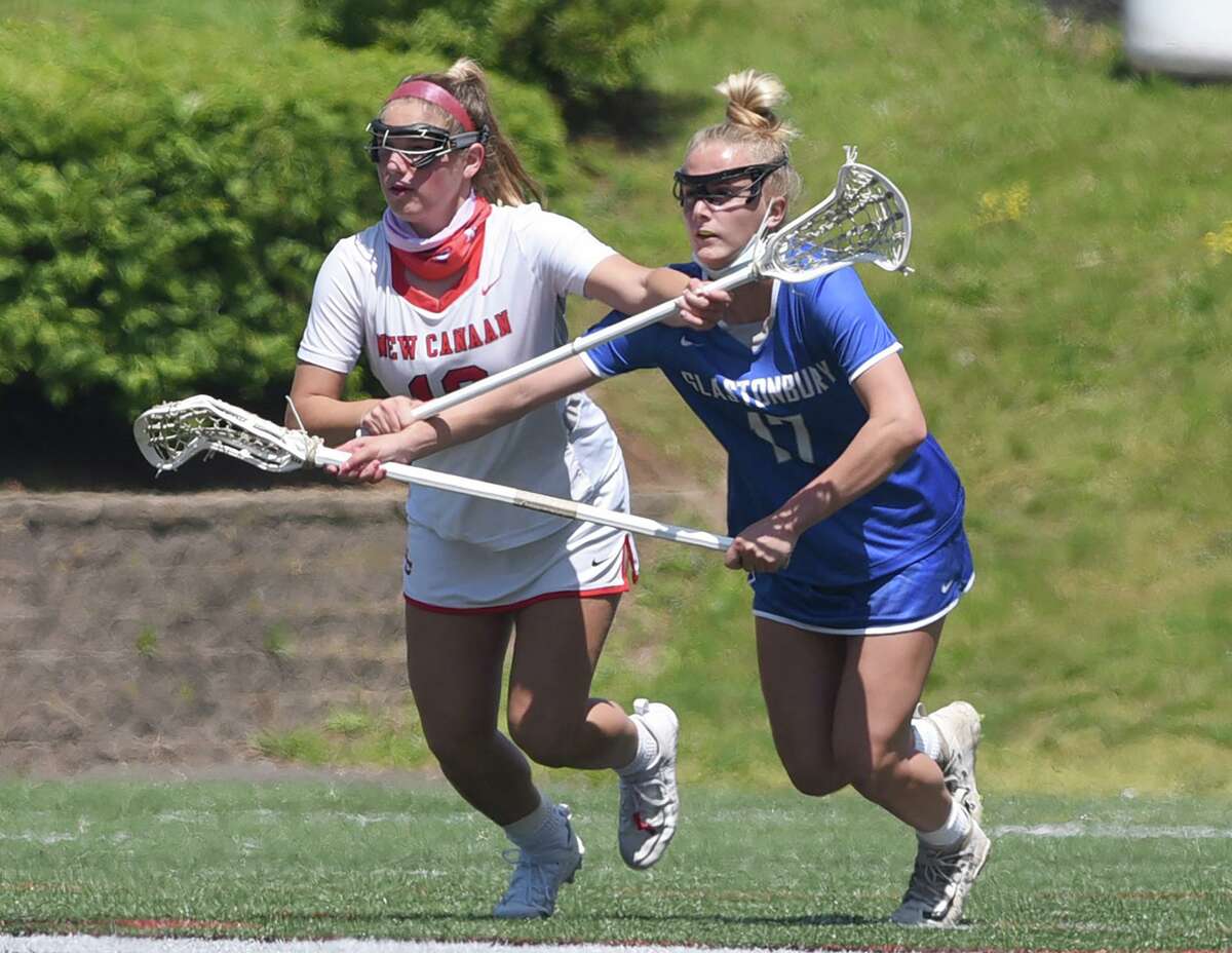 New Canaan's McKenna Harden (13) and Glastonbury's Sam Forrest (17) battles for position during a girls lacrosse game at Dunning Field on Saturday, May 15, 2021. The two will play for North Carolina next year.