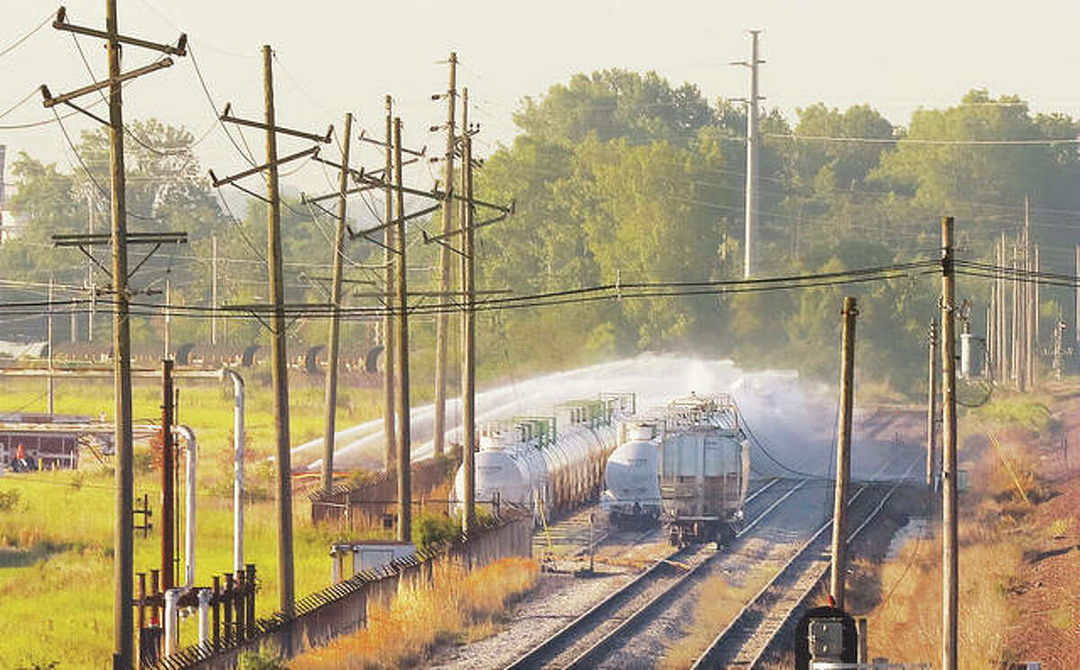 Water cannons on Friday continued to spray a “water curtain” over four tank cars in Wood River Friday that were still venting spent sulfuric acid fumes into the air at dangerous levels near the cars. The shelter-in-place order was lifted for Roxana and parts of Wood River early Friday, but shifting winds forced a scramble to close Illinois 3 to all traffic for more than an hour between Illinois 143 and Hartford during the morning rush hour.