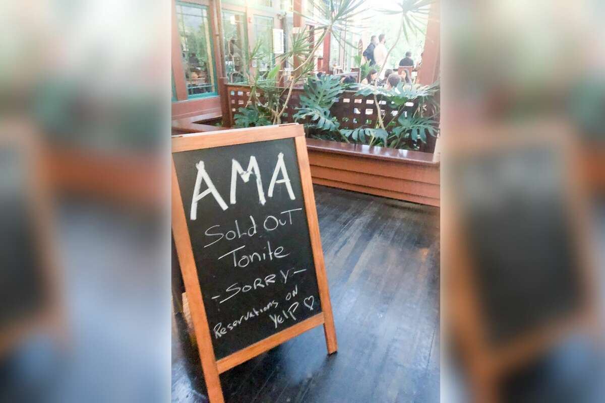A sign in front of AMA restaurant lets customers know they have no more reservations available that evening. 