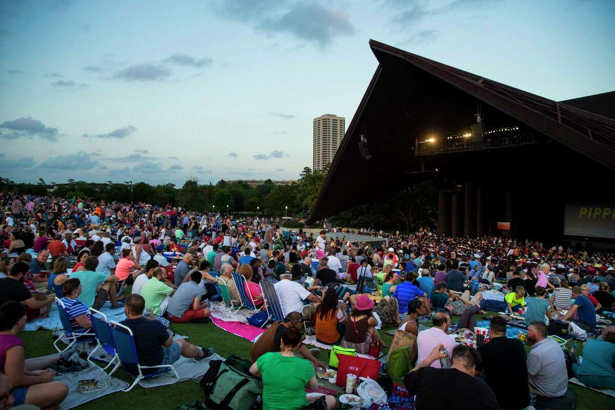 People grab seats on the lawn before a 2017 concert at the Miller Outdoor Theater.