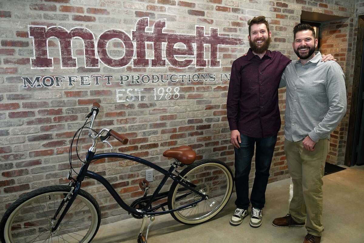 Chris Woher, left, and his brother Jeff, co-owners of Moffett Productions, share a photo in their new business during their grand opening in Tomball on Feb. 1, 2019.