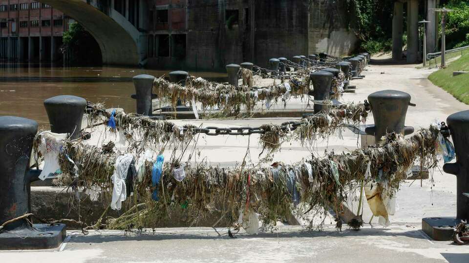 Plastic and other waste is visible along Buffalo Bayou in downtown Houston.