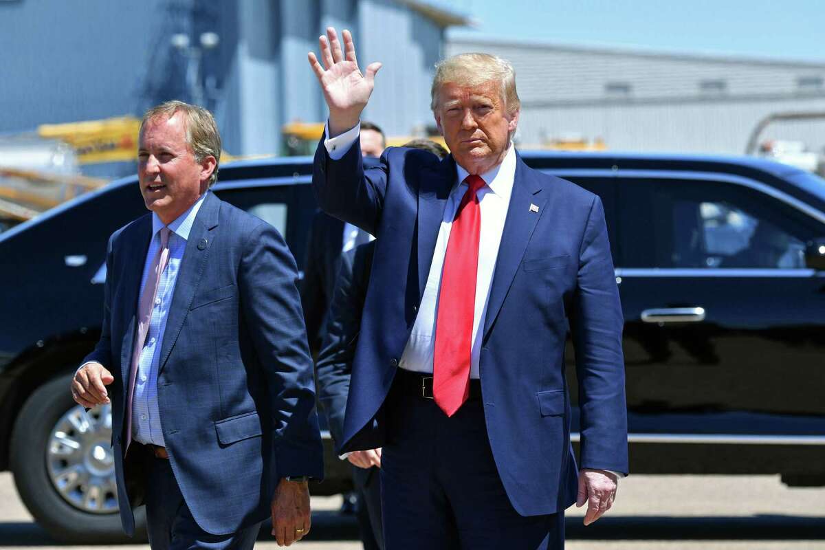 In this file photo, US President Donald Trump waves upon arrival, alongside Attorney General of Texas Ken Paxton (L) in Dallas, Texas, on June 11, 2020. (Nicholas Kamm/AFP via Getty Images/TNS)