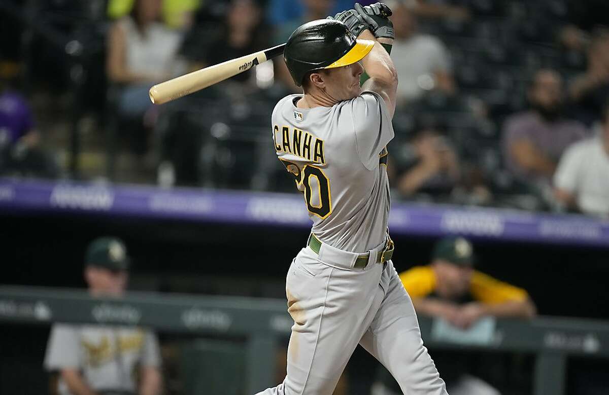Oakland Athletics' Mark Canha follows the flight of his RBI double off Colorado Rockies relief pitcher Chi Chi Gonzalez in the sixth inning.