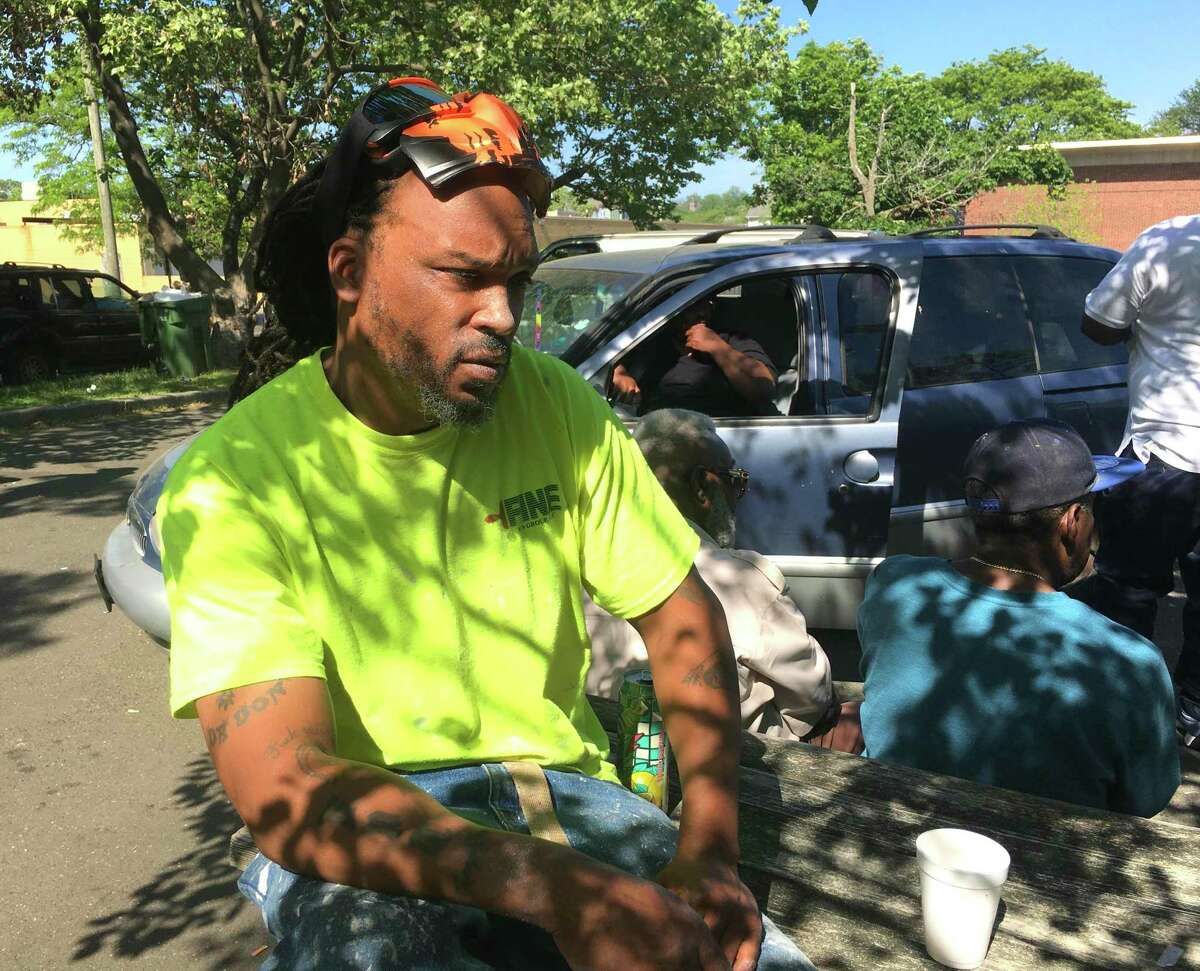 Gathering with friends from New Haven’s Dixwell neighborhood, Edward Booker, 46, of Hamden, talks about his skepticism of the COVID-19 vaccine.