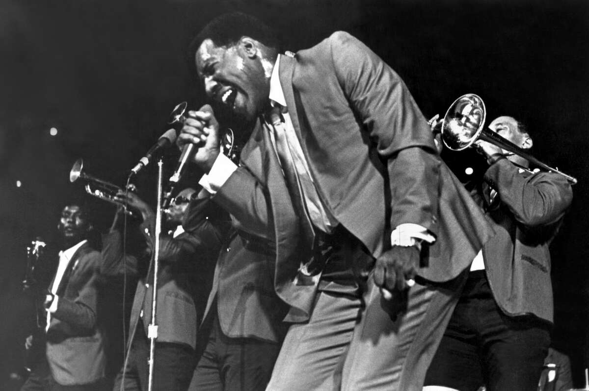 Soul singer Otis Redding passionately sings with his horn section behind him as he performs onstage in 1967.