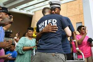 In this file photo, New Haven fire Lt. Samod “Nuke” Rankins, facing, is overcome with emotion as he hugs fellow firefighter James Kiley upon his release from the Bridgeport Hospital burn unit in Bridgeport on May 23.