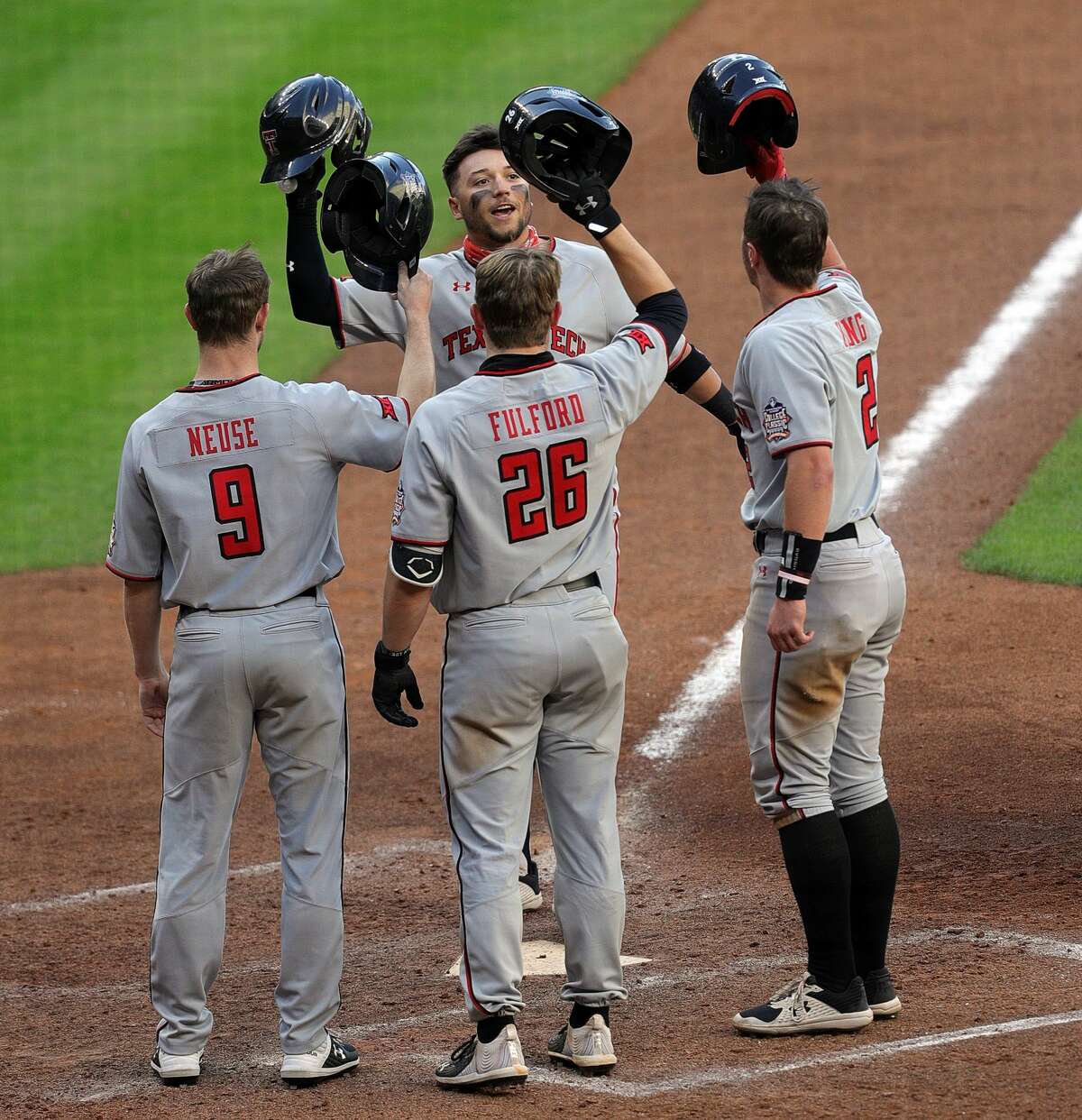 HOUSTON, TEXAS - MARCH 06: Cal Conley #13 of the Texas Tech Red Raiders is congratulated by Dylan Neuse #9, Braxton Fulford #26 and Jace Jung #2 after hitting a home run in the seventh inning against the Sam Houston State Bearkats at Minute Maid Park on March 06, 2021 in Houston, Texas. (Photo by Bob Levey/Getty Images)