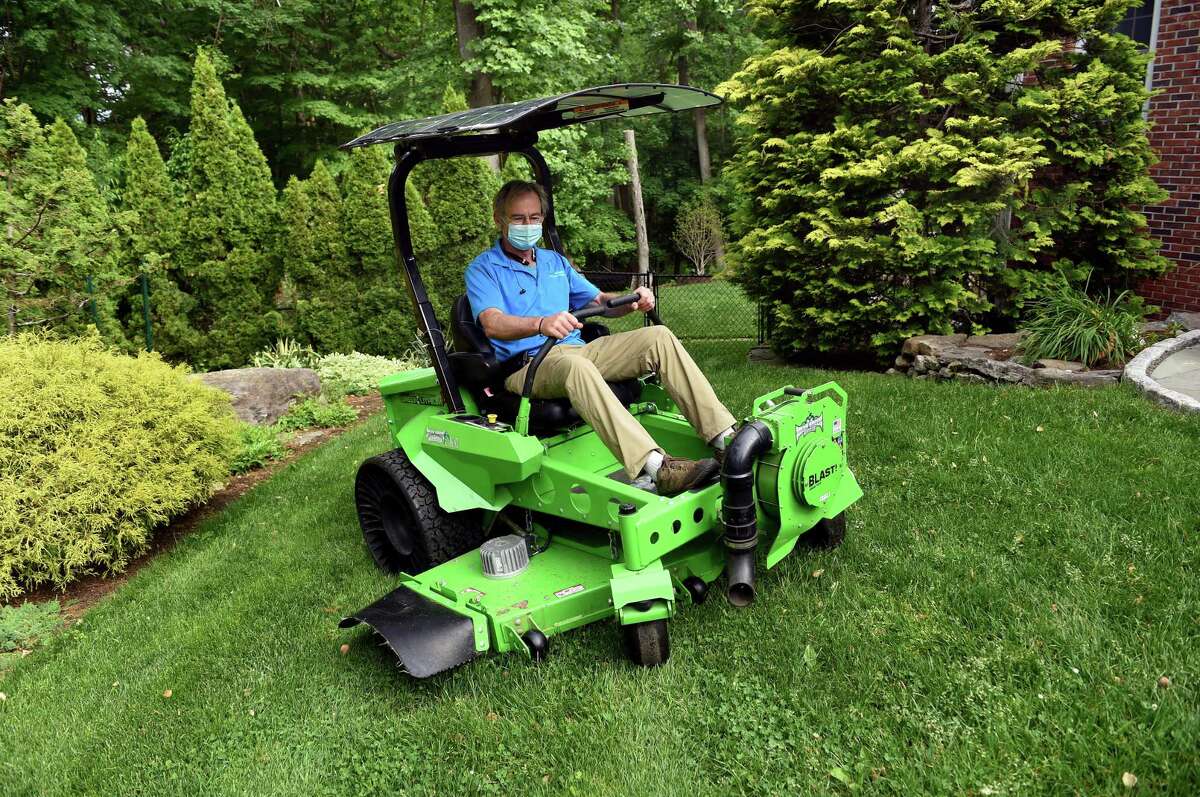 Dan Delvanthal, owner of Mow Green Organic Lawn Care, demonstrates a new battery powered solar charging commercial mower on his lawn in Fairfield on May 28, 2021.