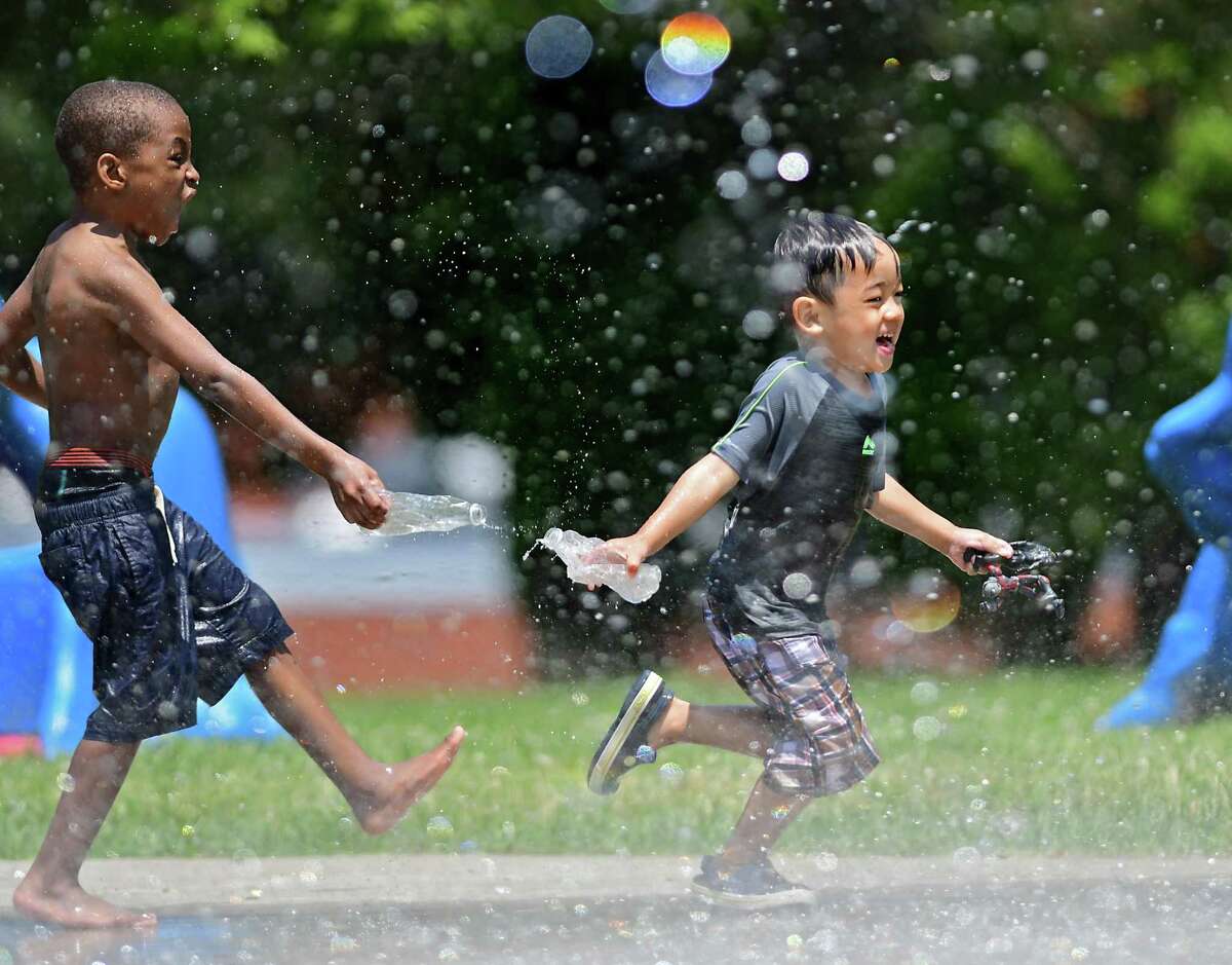 Quincy Washington, 5, of Troy throws water on Tonpaisue Mupwe, 4, of Albany, as they play and keep cool at the splash pad in Lincoln Park on Monday, June 7, 2021 in Albany, N.Y. A heat advisory was issued for another day where temperatures are expected in the 90’s. (Lori Van Buren/Times Union)