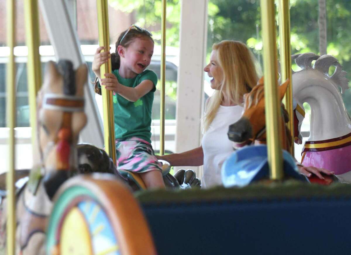 Kayleigh Carey, 7, rides the carousel with Jackie Ryan at the Stamford Public Education Foundation (SPEF) Springtime Celebration at Mill River Park in Stamford, Conn. Sunday, June 6, 2021. The event featured performances by Project Music, Stamford High School's Strawberry Hill Players, Westhill High School's Jazz Ensemble, Stamford High Madrigals, and Stamford Hoop Girls. Rippowam Middle School's Sid Watson provided DJ music between sets and winners of Excellence in Education awards were announced.