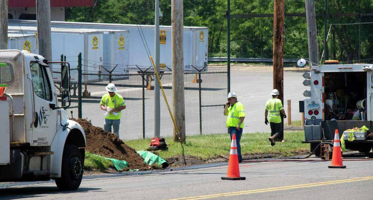 Utility workers fix a gas leak after a line ruptured Monday morning after being struck by a landscape worker.