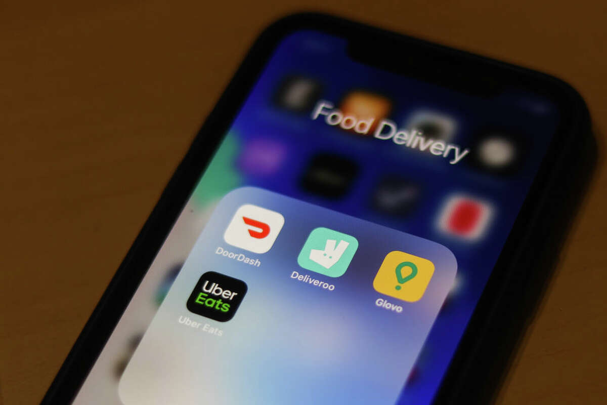 DoorDash, Uber Eats and other food delivery apps are seen on an iPhone screen.
