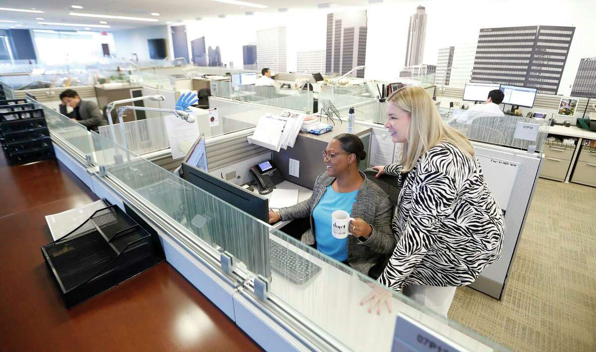 Kimberly Conley, left, and Elizabeth Clampitt collaborate along with others working at their desks at commercial real estate firm JLL, Monday, June 7, 2021, in Houston. A study by JLL shows people are ready to get back to the office, want flexibility in where they work, crave ‘real’ human interactions with colleagues and miss a change of scenery. "Theres a greater desire to leave the home and show up at work in a great workplace," said Dan Bellow, president of JLL Houston.