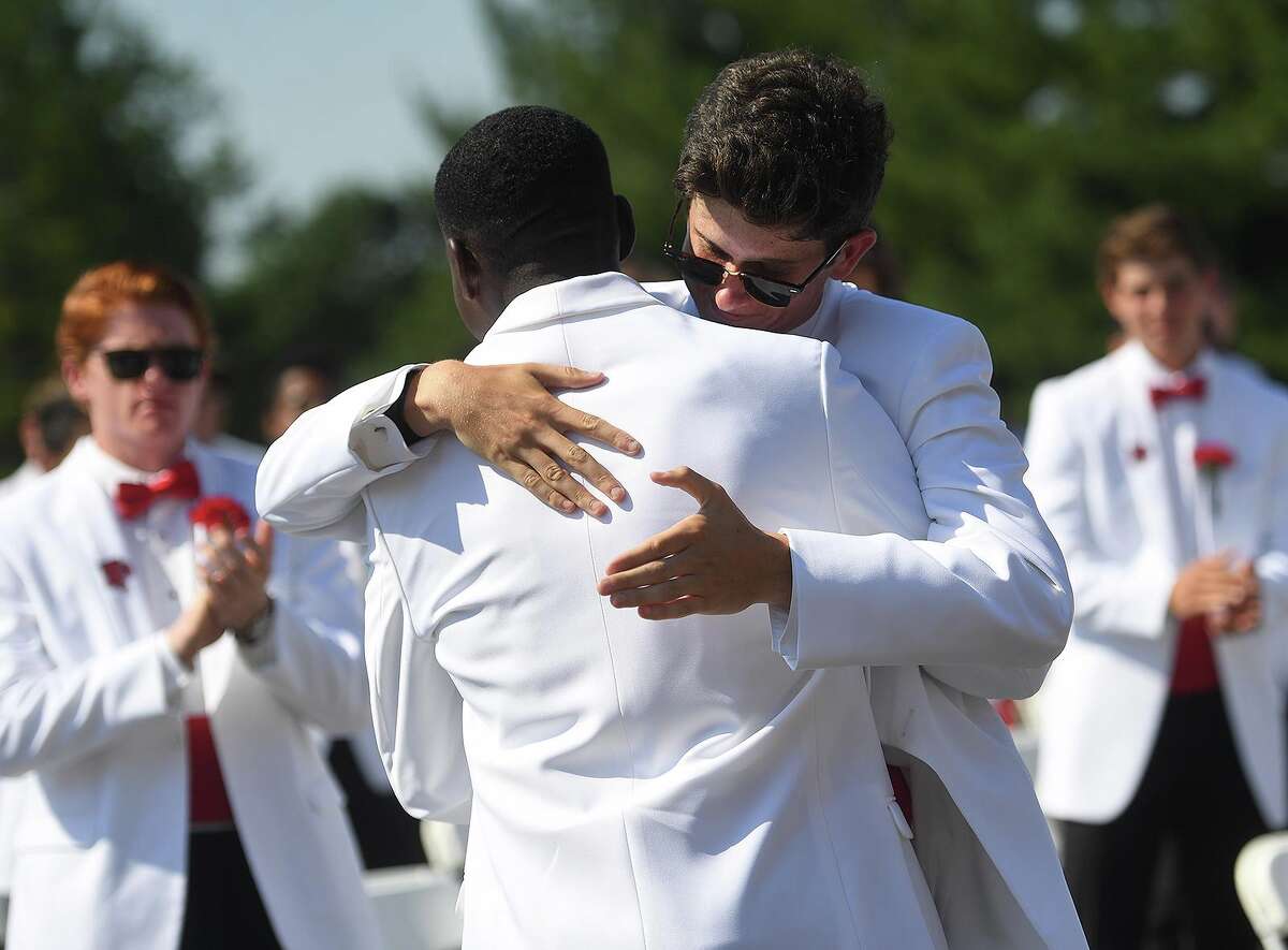 Graduates Caleb Bolden, left, and Ryan Carroll hug following Bolden's delivery of the Farewell Address at the Fairfield Prep graduation on Sunday.