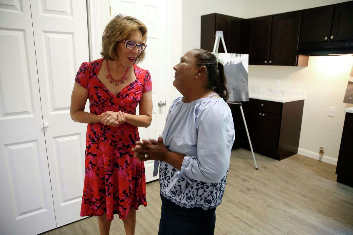 San Antonio City District 5 Councilwoman Shirley Gonzales, left, talks with Laura Martinez, 61, after handing her the keys to her house on Monday. Martinez’s modified shotgun house, nearly 100 years old, was in disrepair and was renovated through a city program.