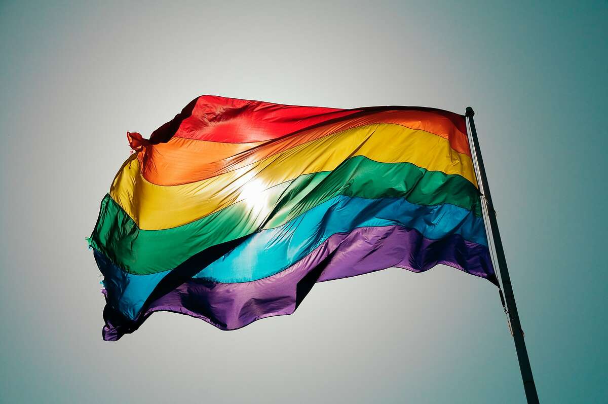 Rainbow Pride flag flies against blue sky in the Castro. 