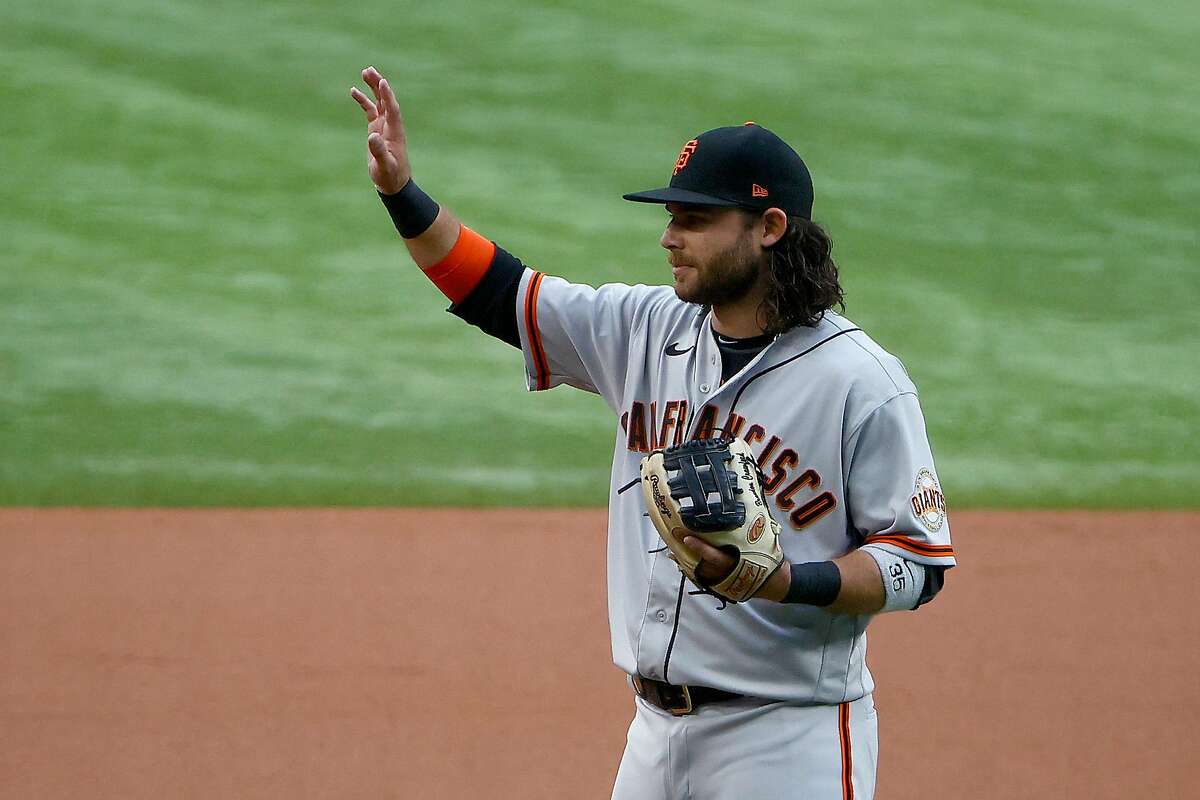 ARLINGTON, TEXAS - JUNE 08: Brandon Crawford #35 of the San Francisco Giants acknowledges his teammates and fans while being recognized for setting a franchise record playing 1,326 games as shortstop with the Giants in the bottom of the first inning at Globe Life Field on June 08, 2021 in Arlington, Texas. (Photo by Tom Pennington/Getty Images)