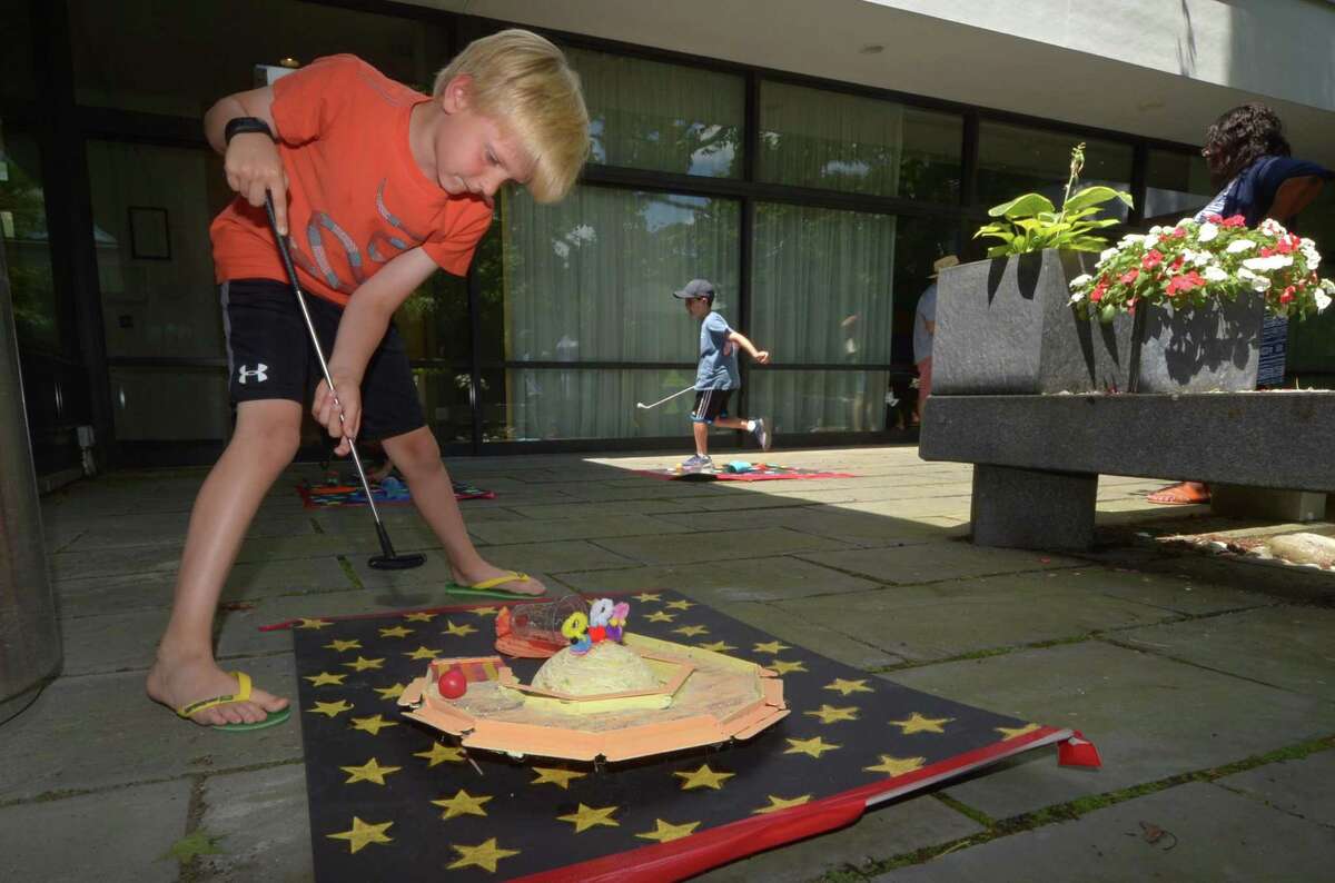 Ian Chase, 8-years-old, plays mini-golf during the Wilton Library Summer Reading Kick-Off, in a recent year. One of the upcoming happenings with the library is the beginning of Summer Reading on Monday, June 14, 2021, which is also Flag Day. The summer reading program will then go through Saturday, August 28, 2021.
