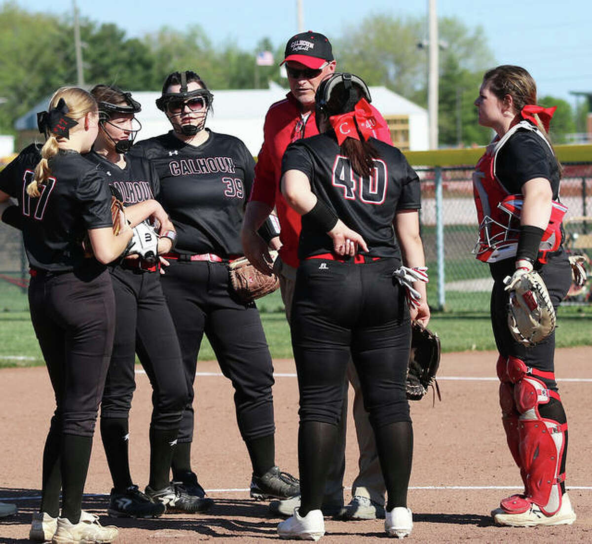 Calhoun coach Duane Sievers meets with some Warriors in a meeting at the pitcher’s circle in a game earlier this season. The Warriors finished the season 14-9 with Tuesday’s sectional defeat in Centralia.