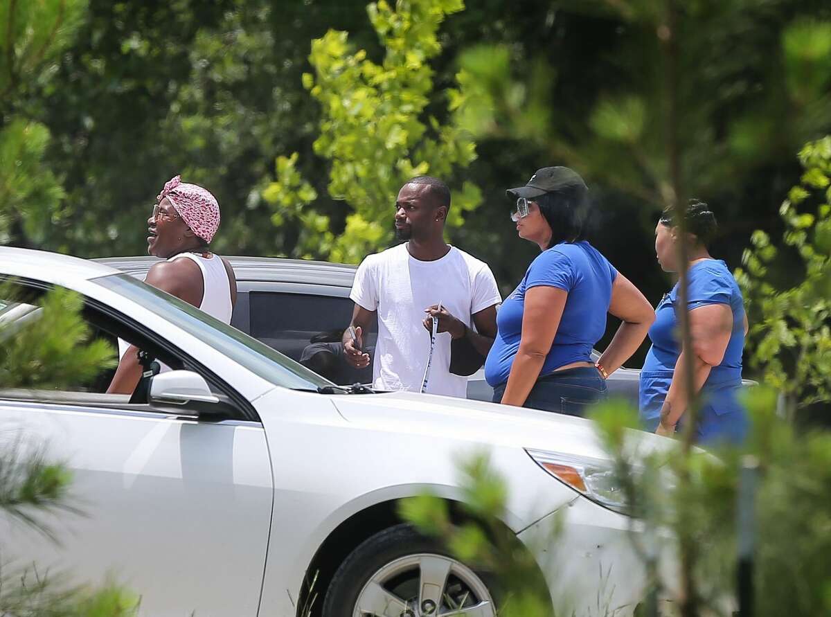 People watch as police investigate the scene of a shooting outside of North Forest High School, Wednesday, June 9, 2021, in Houston.