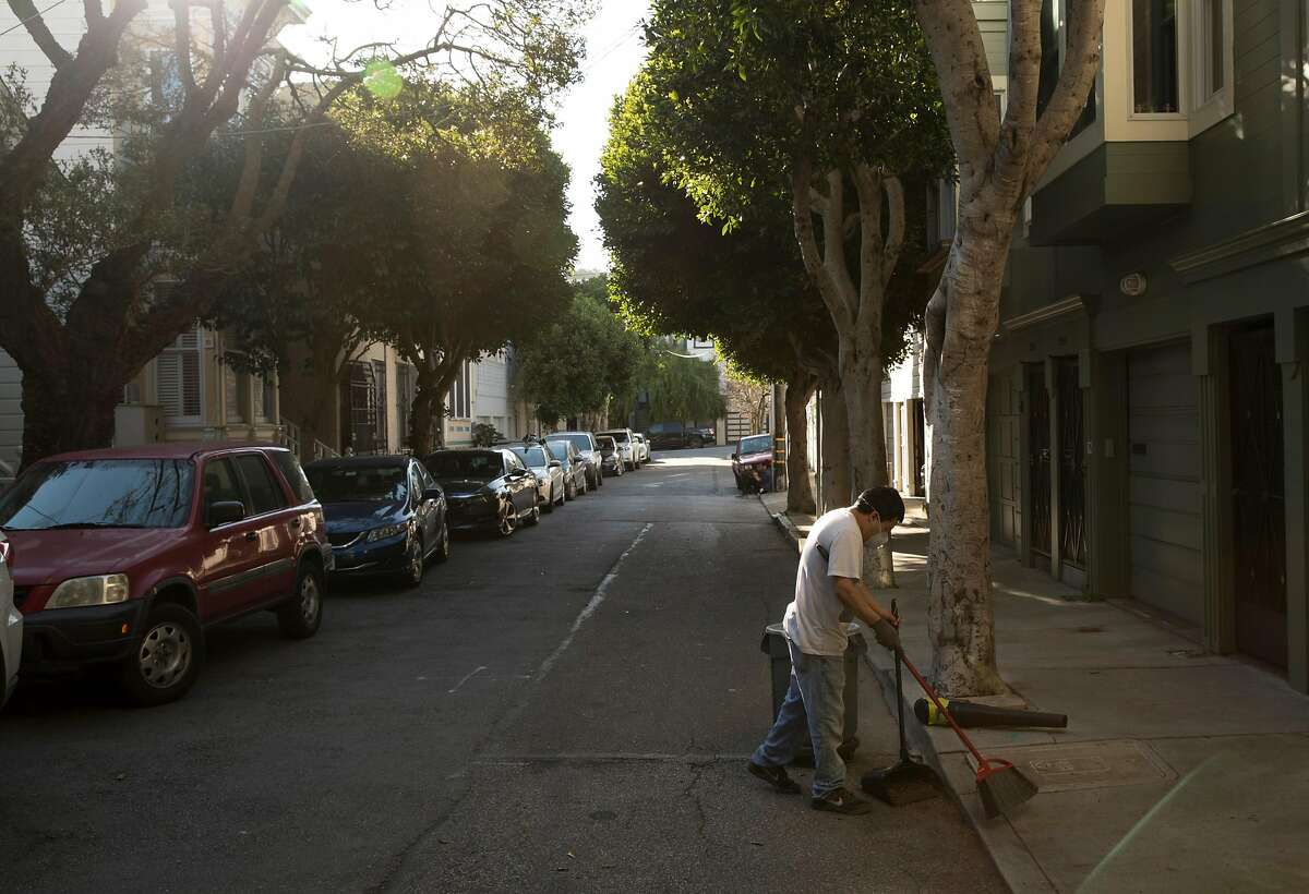 Ozny Lopez cleans up leaves in front of a home on Laussat Alley where neighbors have grown tired enough of trash and human waste being left on their block that they hired their own street cleaner San Francisco, Calif., on Tuesday, February 25, 2020.