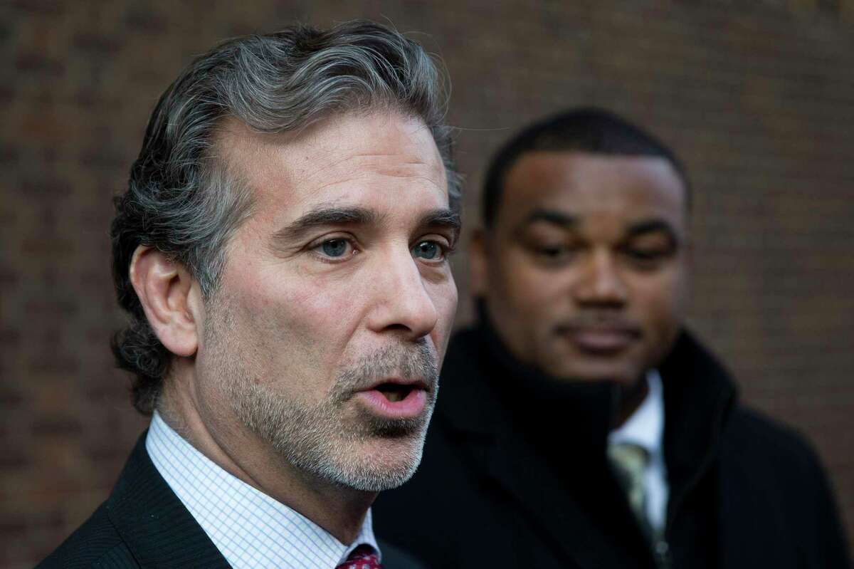 In this Nov. 19, 2014, file photo, lawyer Christopher Seeger, left, and client former NFL player Shawn Wooden speak with members of the media after a hearing on the proposed NFL concussion settlement outside of the U.S. Courthouse in Philadelphia. The NFL on Wednesday, June 2, 2021, pledged to halt the use of “race-norming” — which assumed Black players started out with lower cognitive functioning — in the $1 billion settlement of brain injury claims and review past scores for any potential race bias.