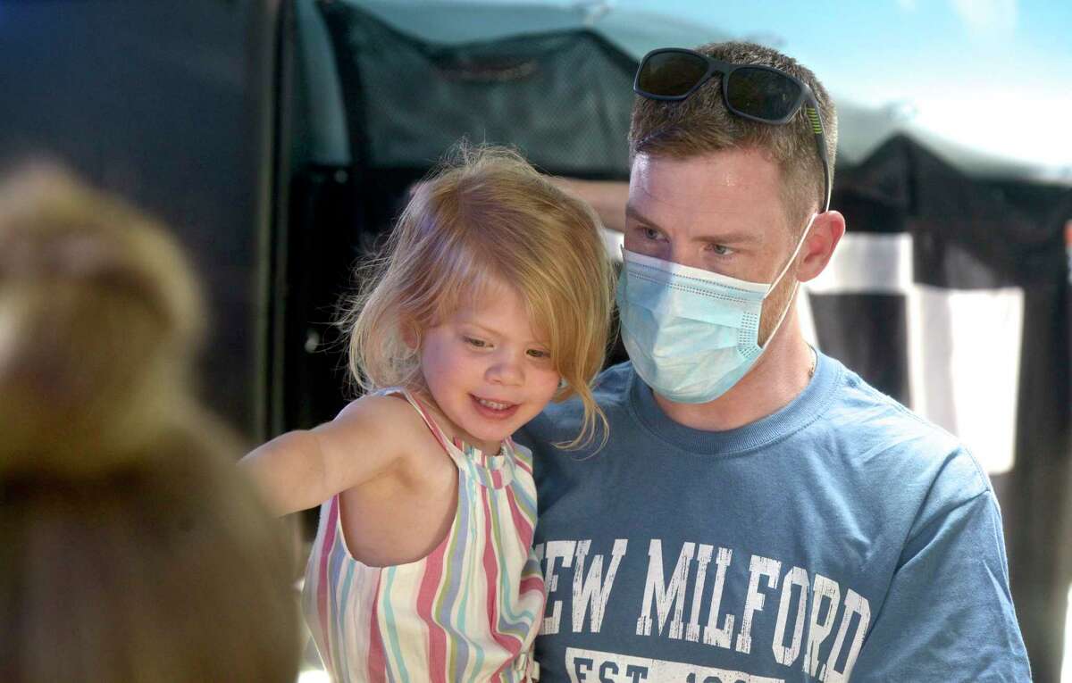 Dakota Rabito, age 3, picks out her ice cream, strawberry with rainbow sprinkles, with her father Jeff Rabito, an Emergency Room (ER) Technician at New Milford Hospital. The hospital had an ice cream social as part of its celebration of 100 years of service. Wednesday, June 9, 2021, in New Milford, Conn.