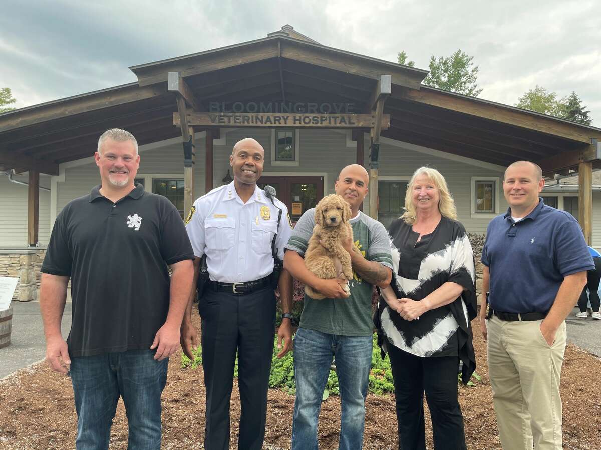 Brian Tierney of Sand Lake Doodles joins Albany Police Chief Eric Hawkins; Officer Joel Caldwell (holding the newest addition to the Albany Police Department, an eight-week-old Goldendoodle); Kathy Rogers, manager and trainer at Bloomingrove Veterinary Hospital in Rensselaer; and Sgt. Daniel Meehan. The pooch is a therapy dog in training.