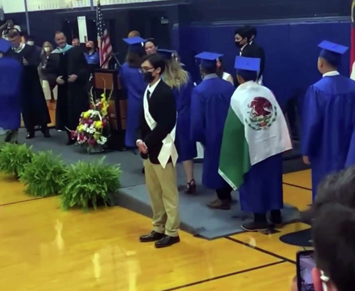 An image provided by Adolfo Hurtado shows Ever Lopez wearing a Mexican flag over his gown at his graduation ceremony in Asheboro, N.C., on Thursday, June 3, 2021. 