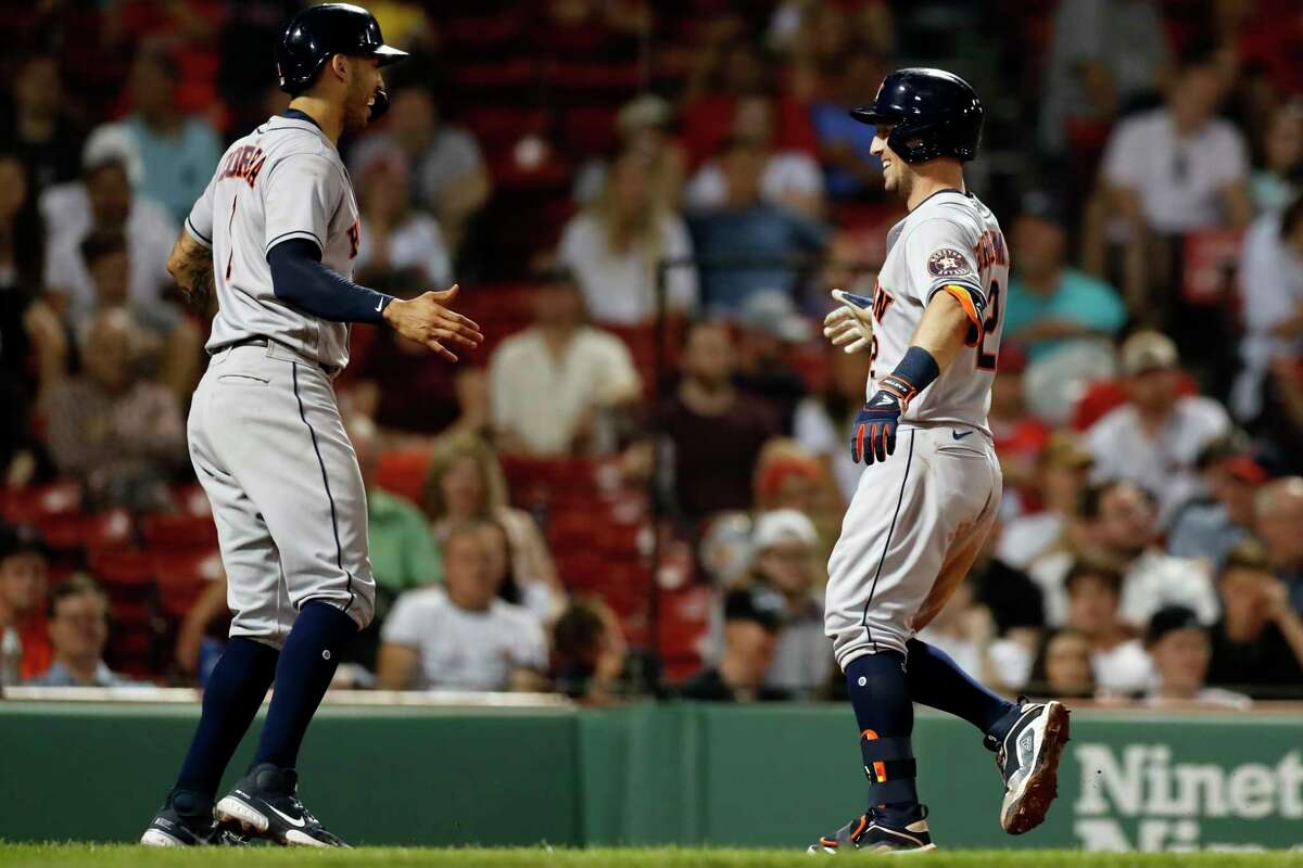 Houston Astros' Alex Bregman (2) celebrates his two-run home run that also drove in Carlos Correa (1) during the eighth inning of a baseball game against the Boston Red Sox, Wednesday, June 9, 2021, in Boston. (AP Photo/Michael Dwyer)