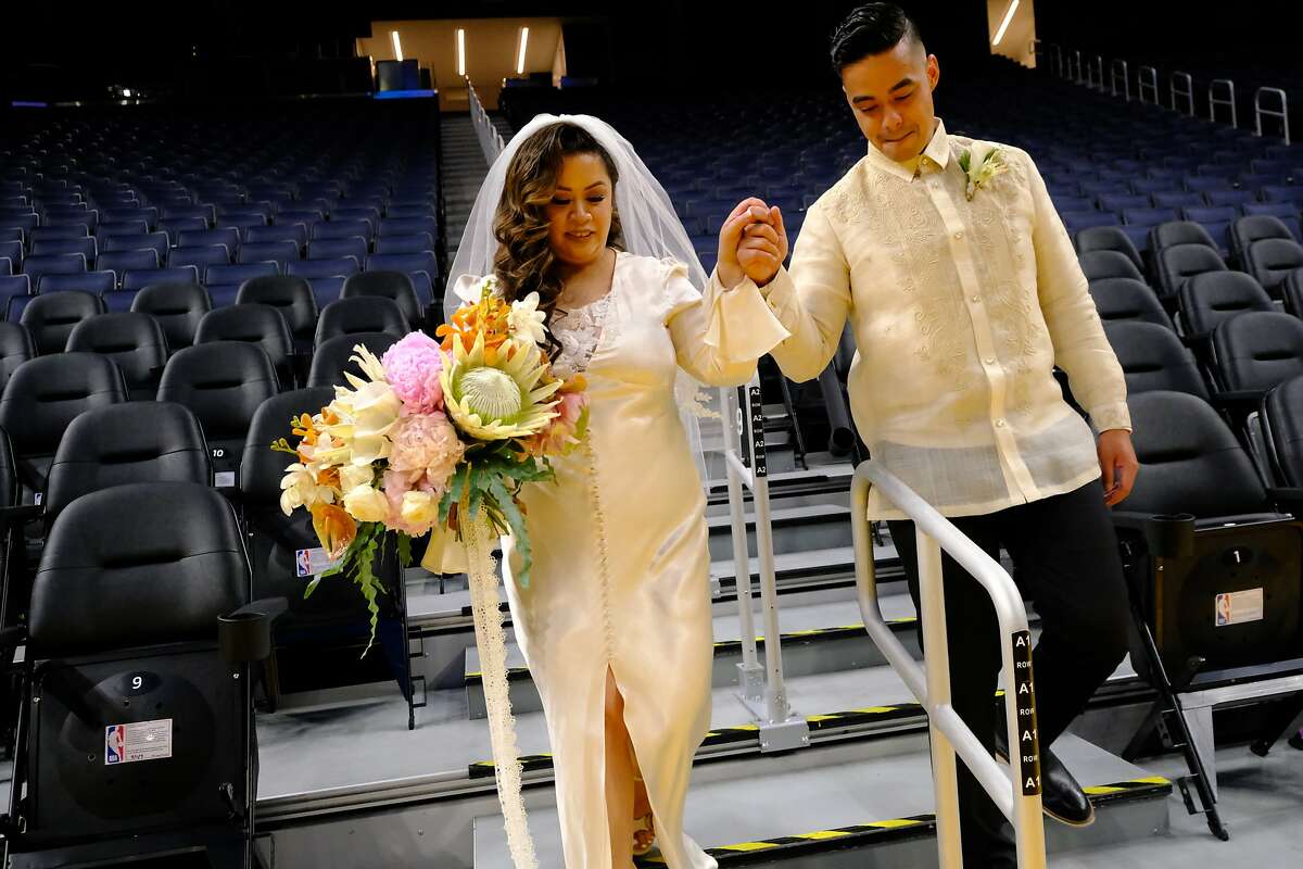 Angelina Marie Yambao and Rowell Fiel walk down to the Chase Center court to take wedding photographs.