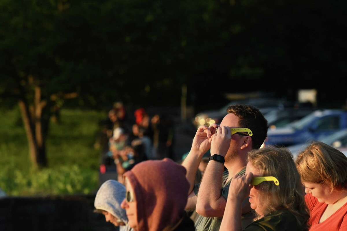 Celestial gazers observe a sunrise solar eclipse from the John Boyd Thacher State Park Overlook on Thursday morning, June 10, 2021, in New Scotland, N.Y. This kind of eclipse has only happened in our area twice in the past 150 years: in 1959 and 1875. (Will Waldron/Times Union)