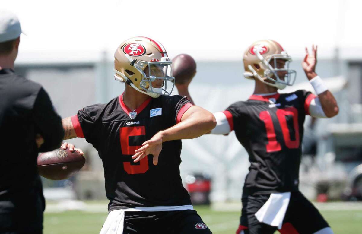 Newly drafted 49ers quarterback Trey Lance (left) practices last year with Jimmy Garoppolo (right) on June 2, 2021 in Santa Clara.