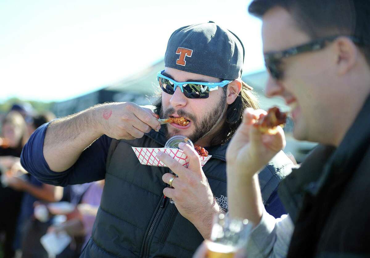 Jason Pfalzgraf, of Milford, samples the mango BBQ wings from the Dew Drop Inn, during 2015’s Annual Hoptoberfest Craft Beer and Wing Festival at the Shelton Riverwalk. Pfalzgraf said that these were the best wings he had tried so far, noting their extra crunch.