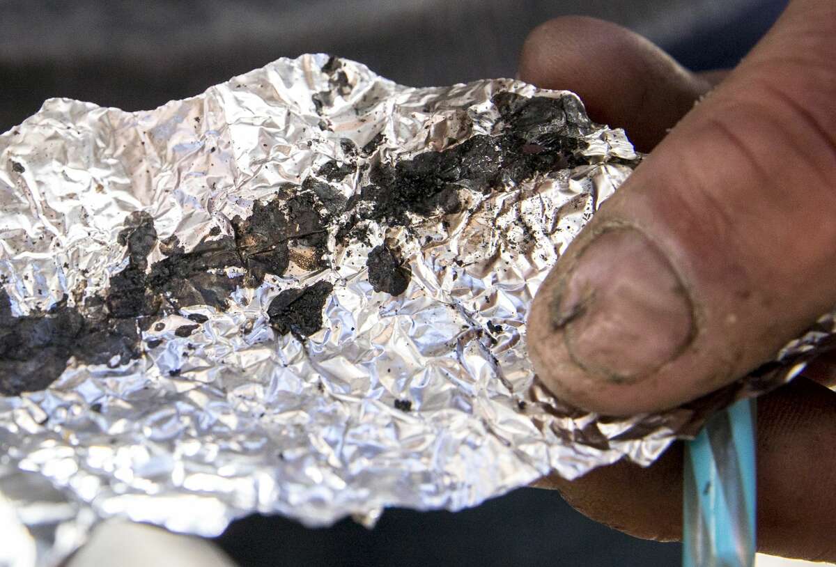 In this file photo, Roger Boyd, 35, holds a piece of foil containing fentanyl while spending time on McAllister Street in the Tenderloin district of San Francisco on June 21, 2019.