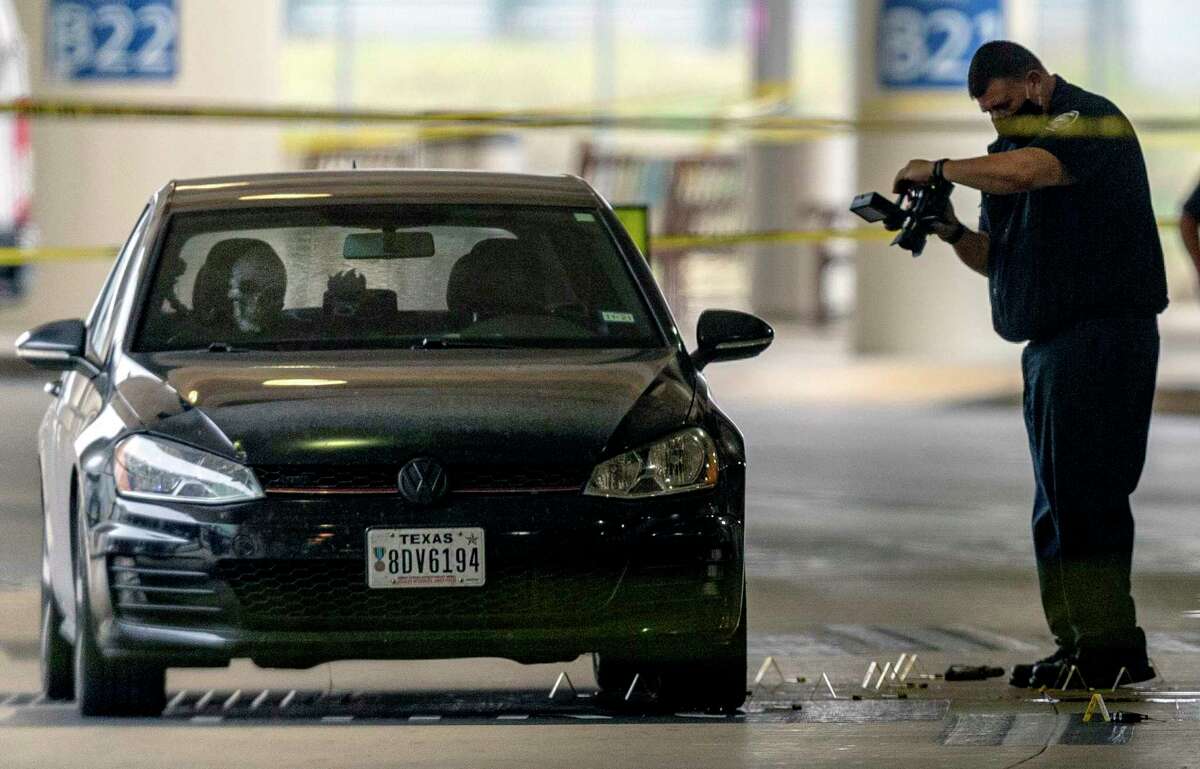 A San Antonio police department official photographs the scene April 15, 2021, around a Volkswagen sedan with disabled veteran plates at the San Antonio International Airport.