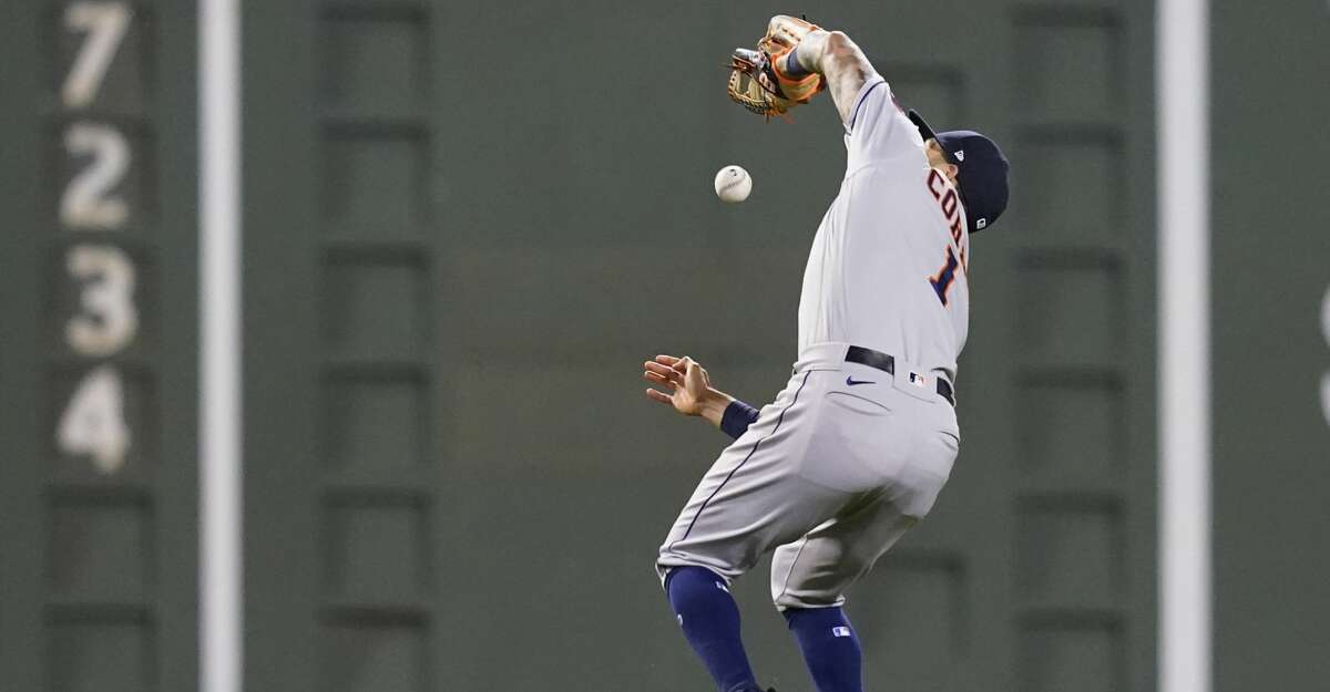 Houston Astros shortstop Carlos Correa drops a pop fly by Boston Red Sox's Rafael Devers who was ruled out due to the infield fly rule in the sixth inning of a baseball game at Fenway Park, Thursday, June 10, 2021, in Boston. (AP Photo/Elise Amendola)